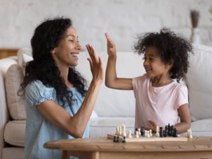 Parent cheering on child playing chess