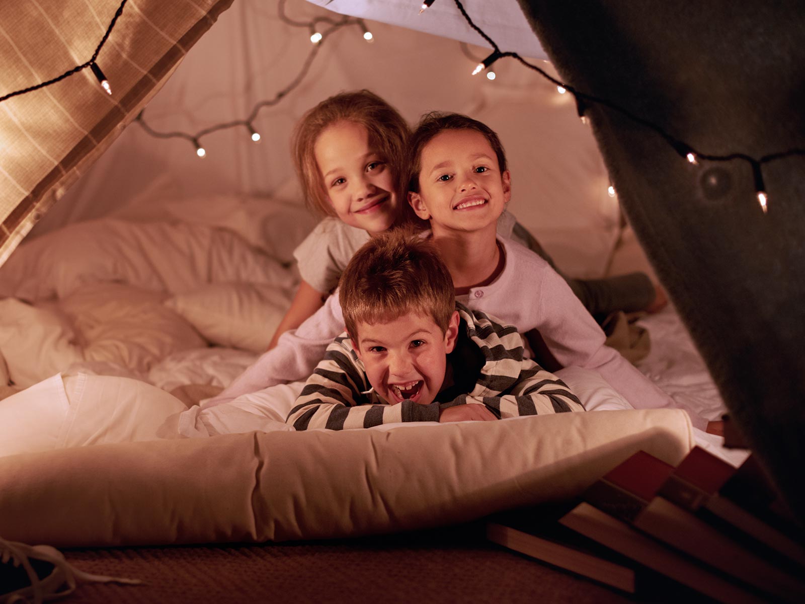 Happy kids in blanket fort