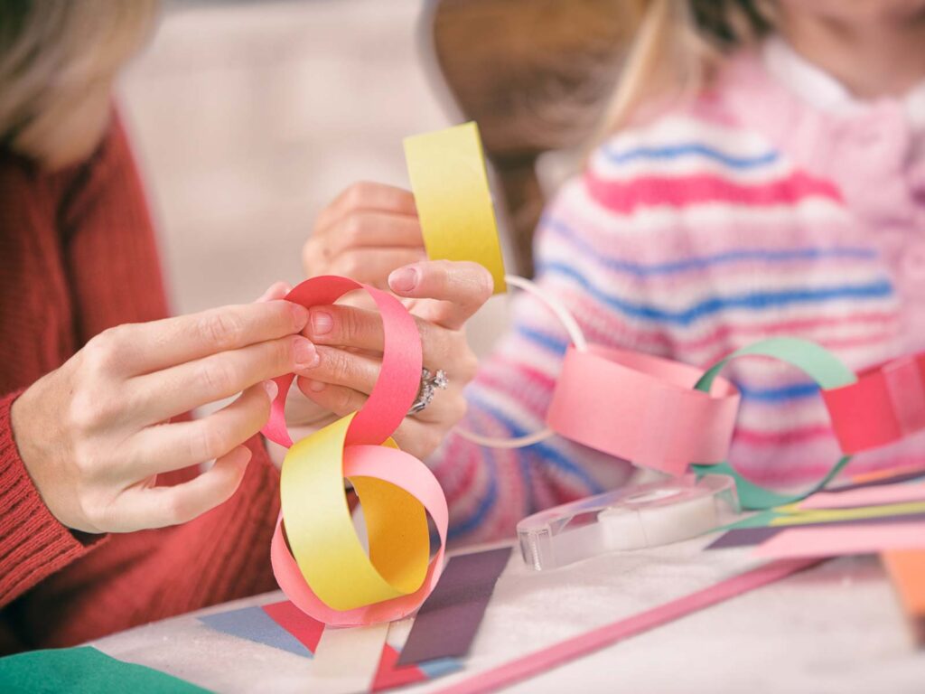 Parent and child making paper chain