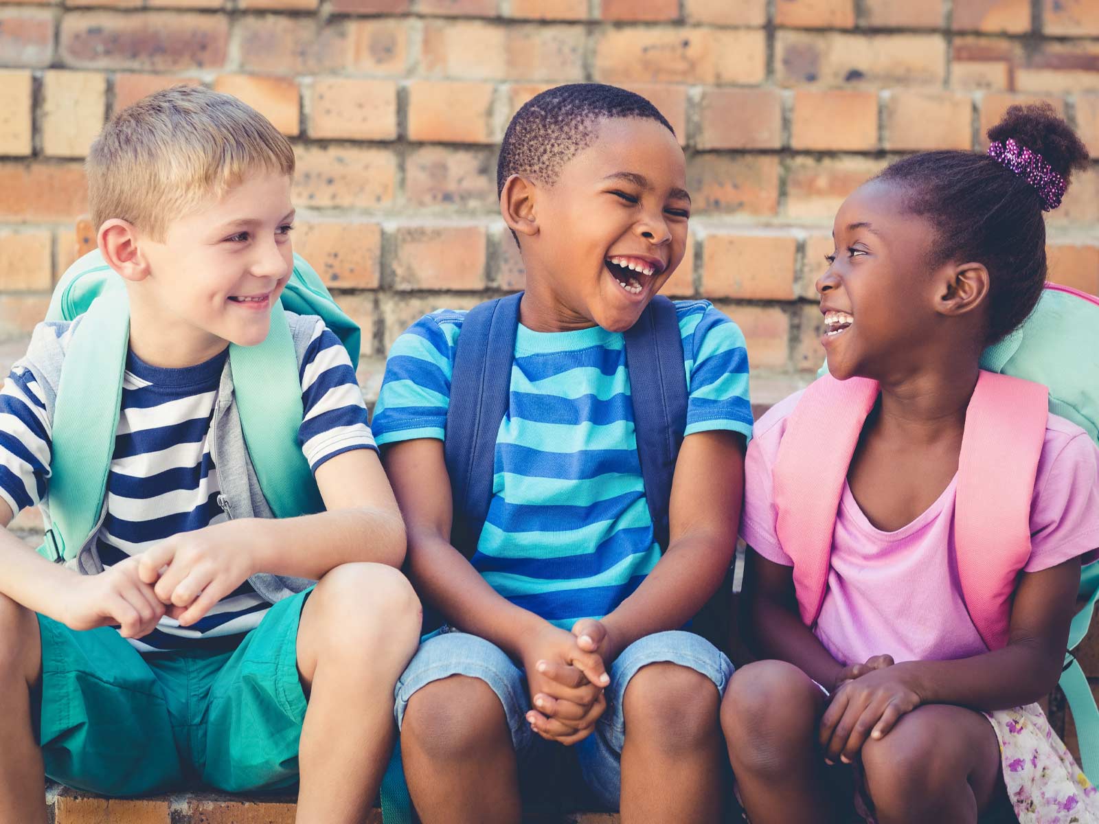 Three happy friends sitting together